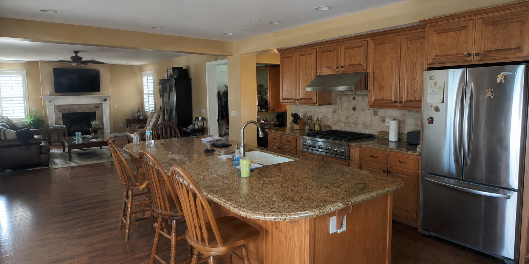 Before kitchen remodeling project featuring traditional wood cabinets, granite countertops, and an open-concept layout.